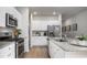 Modern kitchen featuring stainless steel appliances, white cabinets, granite countertops, and stylish decor at 1171 Silver Perch Place, Sunset Beach, NC 28468