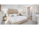 Serene primary bedroom featuring soft lighting, neutral tones, a tufted headboard, and ensuite bathroom at 1171 Silver Perch Place, Sunset Beach, NC 28468