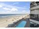 Overhead view of a condo balcony overlooking the ocean, pool, and sandy beach at 1210 N Waccamaw Dr. # 305, Murrells Inlet, SC 29576