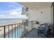 Balcony view overlooking beach, ocean, and pool with casual seating and ocean views at 1210 N Waccamaw Dr. # 305, Murrells Inlet, SC 29576