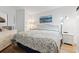 A bright bedroom featuring a queen-size bed with floral bedding, white dresser, and coastal-themed artwork at 1210 N Waccamaw Dr. # 305, Murrells Inlet, SC 29576
