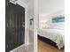 Comfortable bedroom with a black front door, featuring a queen-sized bed with light white wicker headboard and nautical artwork at 1210 N Waccamaw Dr. # 305, Murrells Inlet, SC 29576