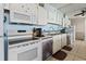 Bright kitchen featuring white appliances, ample cabinet space, and reflective mirrored walls at 1210 N Waccamaw Dr. # 305, Murrells Inlet, SC 29576