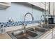Close-up of the stainless steel, double kitchen sink and blue mosaic tile backsplash at 1210 N Waccamaw Dr. # 305, Murrells Inlet, SC 29576