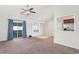 Open-concept living room with carpet, sliding glass doors with curtains, and views into the kitchen and dining area at 1217 Cymmer Ct., Conway, SC 29527