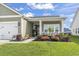 Well-maintained home exterior with a neatly landscaped front yard, flowers, and attached garage at 122 New Paradise Way, Myrtle Beach, SC 29588