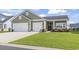 Charming home featuring an attached two car garage, green lawn and landscaping at 122 New Paradise Way, Myrtle Beach, SC 29588