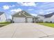 Charming home featuring an attached two car garage, green lawn and landscaping at 122 New Paradise Way, Myrtle Beach, SC 29588