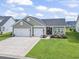 Charming home featuring an attached two car garage, green lawn and landscaping at 122 New Paradise Way, Myrtle Beach, SC 29588