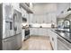 Bright kitchen features white cabinets, stainless steel appliances, and hardwood floors for a modern, clean aesthetic at 122 New Paradise Way, Myrtle Beach, SC 29588