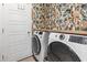 Modern laundry room with advanced washer and dryer units and vibrant patterned wallpaper at 122 New Paradise Way, Myrtle Beach, SC 29588