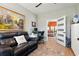 An office or den features a plush leather sofa, desk, and view into the adjoining living room at 122 New Paradise Way, Myrtle Beach, SC 29588
