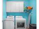 Modern laundry room featuring white appliances, storage cabinets, and an ironing board at 1290 Prescott Circle, Myrtle Beach, SC 29577