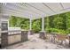 Outdoor kitchen featuring a built-in grill, granite countertop, and shaded pergola with seating at 1290 Prescott Circle, Myrtle Beach, SC 29577