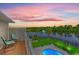 Backyard view overlooking the lake, featuring a swimming pool, patio, and serene seating area at sunset at 131 Sago Palm Dr., Myrtle Beach, SC 29579