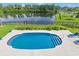 An aerial shot showcases a sparkling pool with a lake view and lush landscaping at 131 Sago Palm Dr., Myrtle Beach, SC 29579