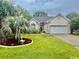 Inviting single-story home featuring lush landscaping, a manicured lawn, and a welcoming front entrance at 1504 Saint Thomas Circle, Myrtle Beach, SC 29577