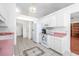 Open kitchen features white appliances, white cabinetry, and tile flooring leading to adjacent rooms at 1527 Hallborough Dr., Surfside Beach, SC 29575