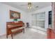 Inviting living room features a piano, window, and ceiling fan with warm lighting at 1527 Hallborough Dr., Surfside Beach, SC 29575