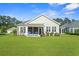 Serene backyard featuring a covered patio with awning, comfortable seating, and well-maintained lawn at 1631 Murrell Pl., Murrells Inlet, SC 29576