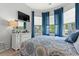 This bedroom features a patterned quilt, blue curtains and a TV at 1631 Murrell Pl., Murrells Inlet, SC 29576