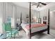 This main bedroom boasts a four-poster bed, tray ceilings, and a comfortable green chair at 1631 Murrell Pl., Murrells Inlet, SC 29576
