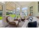 Bright sunroom with wicker furniture offers views of the backyard and lake at 1631 Murrell Pl., Murrells Inlet, SC 29576