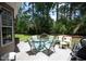 Back patio featuring a round outdoor dining table with lush green backyard views at 170 Glenwood Dr., Conway, SC 29526