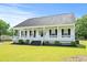 Inviting single-story home showcasing a classic white facade and a spacious front porch at 1763 Lipscomb Rd., Mullins, SC 29574