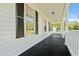 Spacious covered porch with black painted wood, white railing, and natural light at 1763 Lipscomb Rd., Mullins, SC 29574