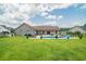 Large backyard with a sparkling pool, patio furniture, and lush green grass at 193 Field Loop Rd., Georgetown, SC 29440
