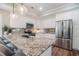 Contemporary kitchen features granite counters, stainless appliances, a breakfast bar, and ample cabinet space at 193 Field Loop Rd., Georgetown, SC 29440
