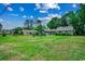 Wide exterior view of home with lush green lawn, mature trees, and blue skies at 2010 Ye Olde Kings Hwy., North Myrtle Beach, SC 29582