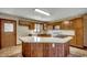 View of kitchen boasting an island with a cooktop, a double basin sink, and plentiful wood cabinetry at 2010 Ye Olde Kings Hwy., North Myrtle Beach, SC 29582