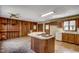Spacious kitchen with wood paneling, central island with cooktop, ample counter space, and wood cabinets at 2010 Ye Olde Kings Hwy., North Myrtle Beach, SC 29582