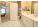 Bright bathroom with white tiled floors, white cabinets, double vanity and view to the adjacent bedroom at 2241 Waterview Dr. # 315, North Myrtle Beach, SC 29582