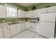 Bright kitchen with white cabinets, white appliances, tiled floors and matching backsplash at 2241 Waterview Dr. # 315, North Myrtle Beach, SC 29582