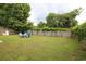 Large, fenced backyard featuring lush green grass and an outdoor fire pit with blue Adirondack chairs at 233 Oak Lea Dr., Conway, SC 29526