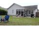 Spacious backyard offering a fire pit, outdoor seating, and a view of the house with a screened-in porch at 233 Oak Lea Dr., Conway, SC 29526
