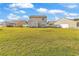 Spacious, grassy backyard with a home and white fence under a partly cloudy sky at 2546 Whetstone Ln., Myrtle Beach, SC 29579