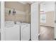 This laundry room features a white washer and dryer, wire shelving, and beige colored walls at 2546 Whetstone Ln., Myrtle Beach, SC 29579