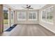 Bright sunroom featuring new laminate flooring, neutral paint, large windows, and a ceiling fan at 2546 Whetstone Ln., Myrtle Beach, SC 29579
