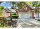 Brick home featuring a two-car garage and a well-manicured front yard with mature trees and plantings at 3071 Alice Ln., Little River, SC 29566