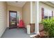 Cozy front porch featuring a red chair, a decorative pillar, and well-maintained landscaping at 309 Rycola Circle, Surfside Beach, SC 29575