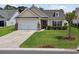 Charming single-story home featuring well-manicured lawn, two-car garage, and mature palm tree at 309 Rycola Circle, Surfside Beach, SC 29575