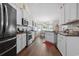 Modern kitchen features white cabinets, stainless steel appliances, and open view to dining area at 309 Rycola Circle, Surfside Beach, SC 29575