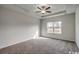 Bedroom featuring plush carpeting, tray ceiling with fan, and window letting in natural light at 319 Garden Grove St, Conway, SC 29526