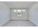 Bright bedroom featuring neutral walls and carpet, with a large window offering outdoor views at 319 Garden Grove St, Conway, SC 29526