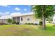 Exterior view of a home's backyard featuring a metal roof, screen porch, patio and landscaping at 323 Waties Dr., Murrells Inlet, SC 29576