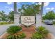 Welcoming entrance to Oak Hampton with brick pillars, mature landscaping, and a clear neighborhood sign at 323 Waties Dr., Murrells Inlet, SC 29576